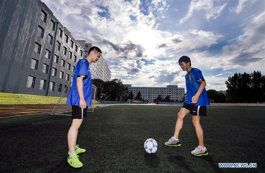 Sun Dongyuan (R) and Fan Changjie have a football training at the special education school of Changchun University in northeast China\'s Jilin Province, June 20, 2018. Sun Dongyuan and Fan Changjie, who were diagnosed with congenital eye disease, learn acupuncture and massage in the school. They are also players of the school\'s football team for visually impaired students. During the match, Sun and Fan identify position via a bell inside the ball and with guides\' instructions. The FIFA World Cup 2018 has become their popular topic since June 14, and they listen to the live broadcast and cheer for their favorite teams. (Xinhua/Xu Chang)