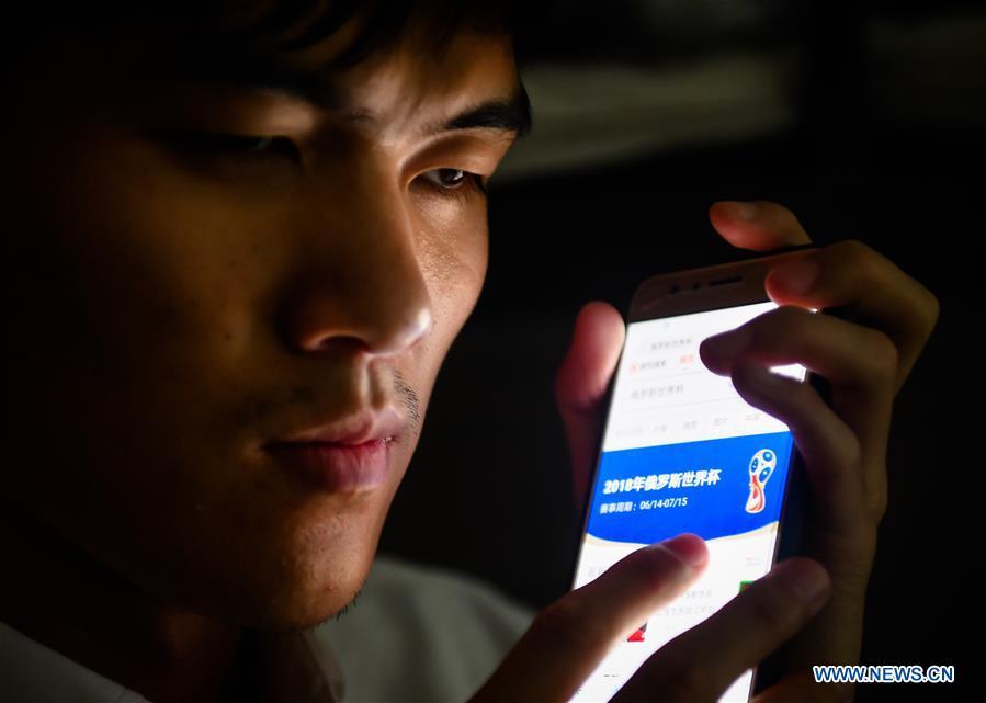 Sun Dongyuan listens to match information of the FIFA World Cup in his dormitory at the special education school of Changchun University in northeast China\'s Jilin Province, June 20, 2018. Sun Dongyuan and Fan Changjie, who were diagnosed with congenital eye disease, learn acupuncture and massage in the school. They are also players of the school\'s football team for visually impaired students. During the match, Sun and Fan identify position via a bell inside the ball and with guides\' instructions. The FIFA World Cup 2018 has become their popular topic since June 14, and they listen to the live broadcast and cheer for their favorite teams. (Xinhua/Xu Chang)