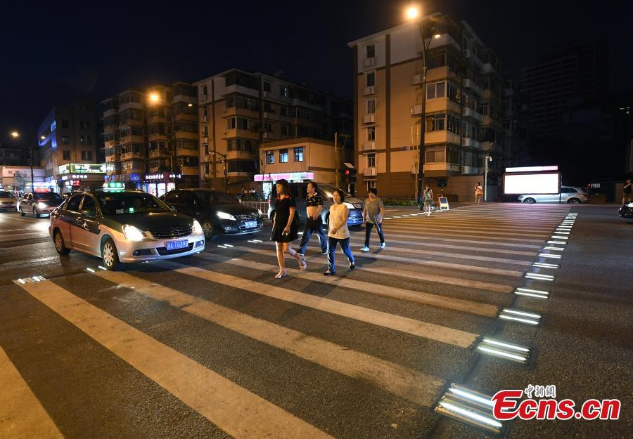 Lights on two sides of a zebra crossing on a street in Zhejiang Province will automatically light up when they sense pedestrians, reminding cars to slow down.
 (Photo: China News Service/Wang Gang)