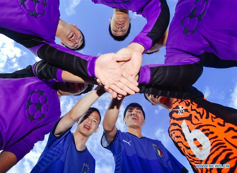 Some football players of the special education school of Changchun University gather before a training in Changchun, northeast China\'s Jilin Province, June 20, 2018. Sun Dongyuan and Fan Changjie, who were diagnosed with congenital eye disease, learn acupuncture and massage in the school. They are also players of the school\'s football team for visually impaired students. During the match, Sun and Fan identify position via a bell inside the ball and with guides\' instructions. The FIFA World Cup 2018 has become their popular topic since June 14, and they listen to the live broadcast and cheer for their favorite teams. (Xinhua/Xu Chang)