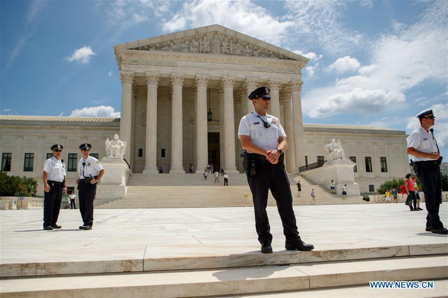 Police officers stand guard amid protest outside U.S. Supreme Court in Washington D.C., the United States, on June 26, 2018. U.S. Supreme Court on Tuesday ruled President Donald Trump\'s travel ban on several Muslim-majority countries is lawful. (Xinhua/Ting Shen)