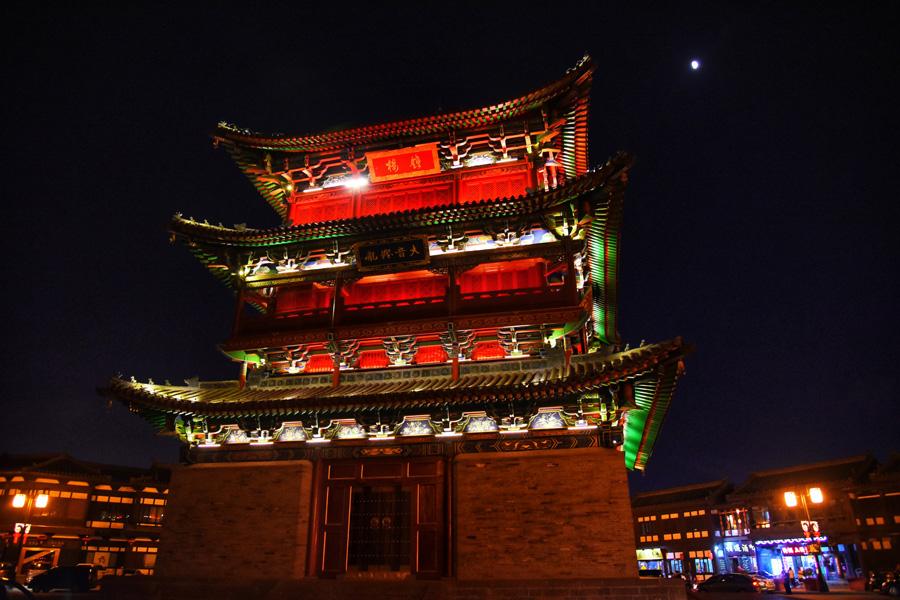 A magnificent night view of Datong Bell Tower to decorate the city. (Photo/chinadaily.com.cn)

In many historical Chinese cities, the ancient city walls stand downtown, forming a spectacular combination of the past and present — of a historical relic and a modern metropolis. Datong\'s city walls are no exception.

The ancient city wall of Datong was built in the fifth year of the Hongwu Period during the Ming Dynasty (1368-1644) by Xu Da, a senior general of the dynasty. In building it he utilized old ramparts of the previous Northern Wei, Tang, Liao, and Yuan dynasties. The Datong city wall has four sides, covering an area of 3.28 square kilometers.

If you pay a visit to the city walls in the evening, you will see great differences between day and night. Lighting on the interval towers are switched on as night falls, creating a surreal and romantic scene.

Standing on this wall, one can’t help but imagine rows of archers, guns, cannons and soldiers trying to defend the city from invaders.

In ancient times, each city\'s walls were made of different layers varying in scale and form. There were strict rules for height, width, as well as number of gates and towers depending on whether the city was the capital, a provincial capital or a county.

The study of these ancient walls has helped experts to learn more about traditional Chinese culture and history.