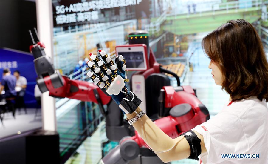 A staff member shows remote control with 5G and artificial intelligence (AI) technologies during the Mobile World Conference Shanghai (MWCS) 2018 in east China\'s Shanghai, June 27, 2018. The three-day MWCS 2018 kicked off at the Shanghai New International Expo Center on Wednesday, showing trending mobile products, services and technologies. (Xinhua/Fang Zhe)