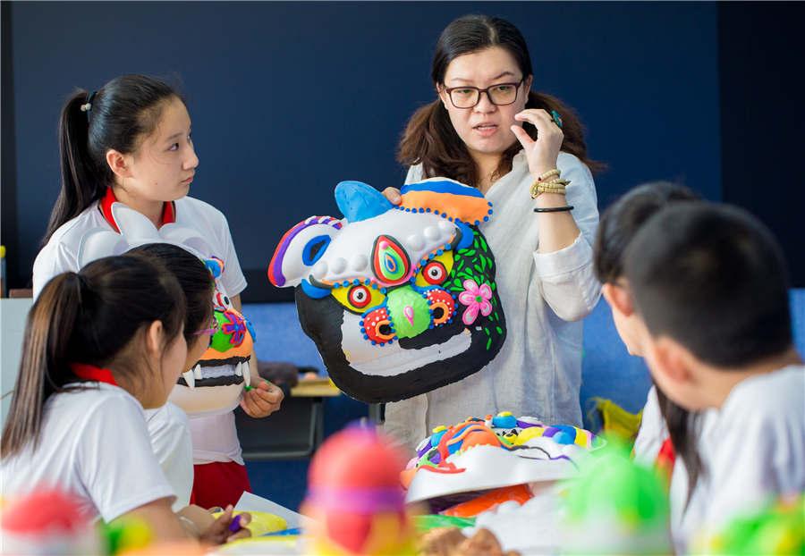 A teacher instructs students in making auspicious beast masks at the Nanchafang Primary School in Hohhot, Inner Mongolia autonomous region, on June 27, 2018. (Photo/Asianewsphoto)

Students from Nanchafang Primary School in Hohhot, Inner Mongolia autonomous region, learned to make a traditional auspicious beast mask under the guidance of teachers. They use super light clay to make a half-relief type lion mask, and got to know the cultural connotations of the craft, experiencing traditional culture directly.