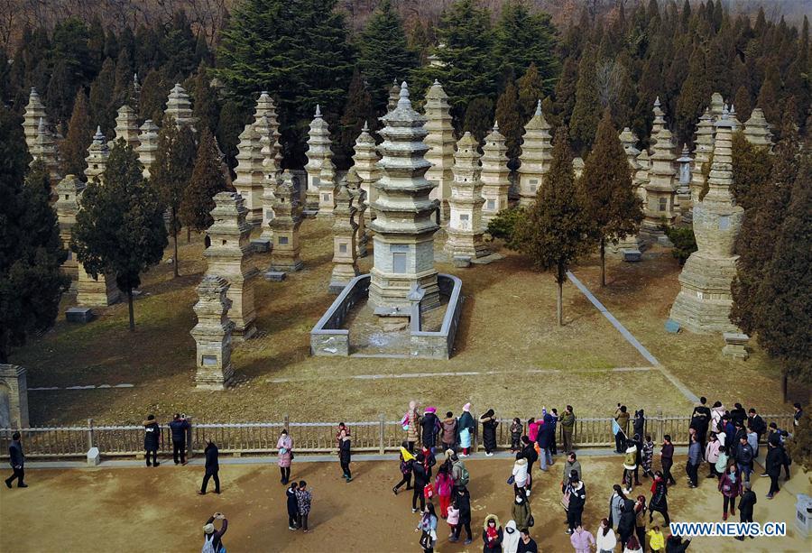 Tourists visit the Pagoda Forest of Shaolin Temple in Dengfeng City, central China\'s Henan Province, Jan. 30, 2017. The Pagoda Forest of Shaolin Temple has been the largest of its kind so far in China with over 230 pagodas. Pagodas built in ancient times in Henan act not only as landmarks for sight-seeing, but also as observers of the Chinese history. (Xinhua/Li An)