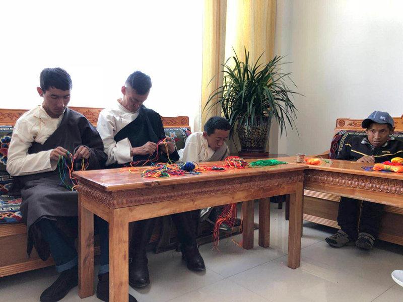People with disabilities weave Tibetan knot at a welfare center in Lhasa, Tibet autonomous region, June 20, 2018. By making some handicrafts, these people can earn money to support their families. (Photo provided to chinadaily.com.cn)

Social security system

On the plateau with average elevation over 3,500 meters, a welfare center for the disabled provides dignified lives.

The center, which opened at Dagze county in 2015, can support 100 people with disabilities to live, undergo rehabilitative training, and enjoy entertainment avenues.

Currently, 18 people with disabilities are living in the center, and they are also taught some skills such as literacy, planting and hand knitting by teachers hired by the center.