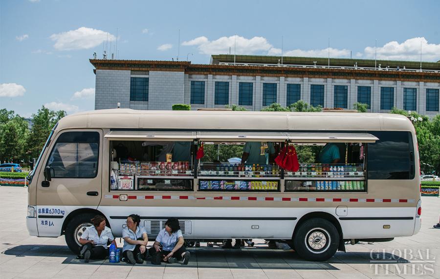 Workers at Tiananmen Square escape the heat in the shade of a mobile snack shop in Beijing on Thursday. (Photo: Li Hao/GT)
