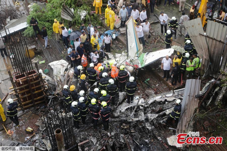 Rescuers stand amid the wreckage of a private chartered plane that crashed in Ghatkopar area, Mumbai, India, June 28, 2018. Five people including one person on the ground were killed. (Photo/Agencies)