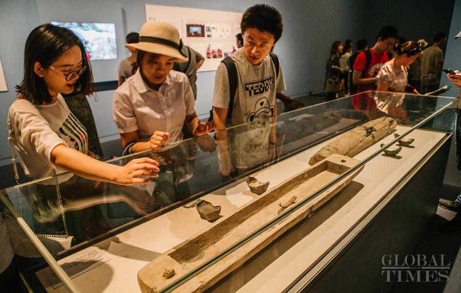 Visitors view a wooden sheath discovered in the ruins that verifies a legend saying that Zhang Xianzhong used to hide silver bars inside wooden sheaths. (Photo: Li Hao/GT)