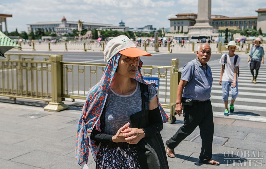 A woman keeps covered to escape the sunshine in Beijing on Thursday as the city experiences a heat wave. (Photo: Li Hao/GT)