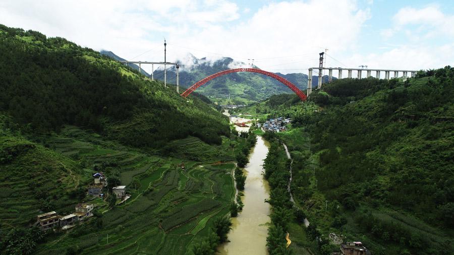 The last section is put into the position to finish the main span of the Daxiaojing Bridge in Guizhou Province, June 30, 2018.  (Photo//chinadaily.com.cn)

Workers have successfully completed the closure of the top-bear concrete-filled steel tube arch bridge with the world\'s longest span of its kind in Southwest China\'s Guizhou Province when they installed the last steel tube on Saturday.

The bridge is 1.5 kilometers long, with its main span 450 meters, over the Dajing River in Luodian county. It is the core project of the highway from Yuqing to Anlong in Guizhou.

According to a worker, the bridge has a total of 58 sections, and the largest one weighs 160 tons. Each section will be lifted 200 meters in the air and moved 550 meters to its position.

After the closure, workers will fill concrete into the eight major steel tubes.

The bridge will shorten the drive time to one hour between Pingtang town and Luodian town.