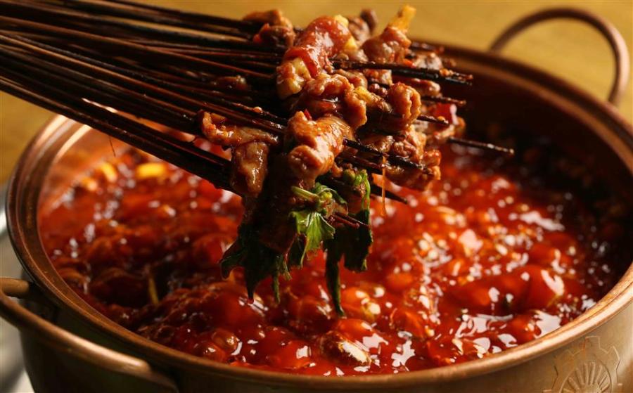 Chuanchuanxiang is a hot pot that cooks ingredients on skewers/sticks. (Photo/Shine.cn)

Chuanchuanxiang

Cooked and served in skewers, chuanchuanxiang can be described as one form of hotpot, or mini hotpot as some people call it. The word chuanchuan means sticks/skewers.

Originating in Chengdu, this spicy delicacy cooks all kinds of vegetable and meat skewers in hot spicy broth, just like hotpot but with skewers, and the cost of the meal is calculated by counting the number of skewers.

The chuanchuanxiang broth is filled with herbs and spices to elevate the depth of flavor, like caoguo (Amomum tsao-ko), fennel, baidoukou (Amomum kravanh), cloves and star anise. One can choose spicy or original broth, which has the same base of chicken or pork stock but different kinds and amount of seasonings.

Beef, shrimp, tofu and vegetables are the basic ingredients in chuanchuanxiang, and offal such as chicken heart, duck intestine and beef tripe are what makes a meal complete and authentic. When cooked in the spicy broth, the not-so-appetizing offal parts become mouthwatering delicacies.

Like hotpot, chuanchuanxiang is served with dipping sauces on the side. The traditional Sichuan flavor is made of a bowl of sesame oil-based sauce and a plate of dry ground chilies, toasted white sesame seeds and crushed peanuts.