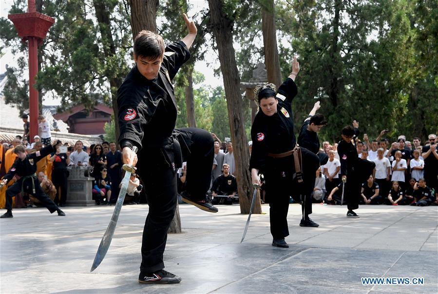 American Kungfu enthusiasts perform martial arts at Shaolin Temple on the Mount Songshan, central China\'s Henan Province, July 1, 2018. Over 200 Kungfu enthusiasts from America made a trip to the Shaolin Temple and performed martial arts with local monks. (Xinhua/Li An)
