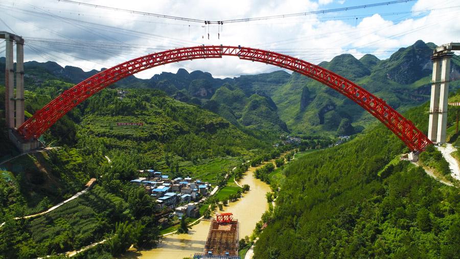 The last section is put into the position to finish the main span of the Daxiaojing Bridge in Guizhou Province, June 30, 2018.  (Photo//chinadaily.com.cn)