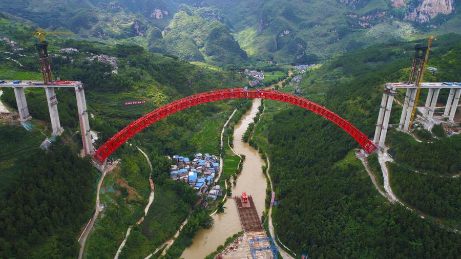 The last section is put into the position to finish the main span of the Daxiaojing Bridge in Guizhou Province, June 30, 2018.  (Photo//chinadaily.com.cn)