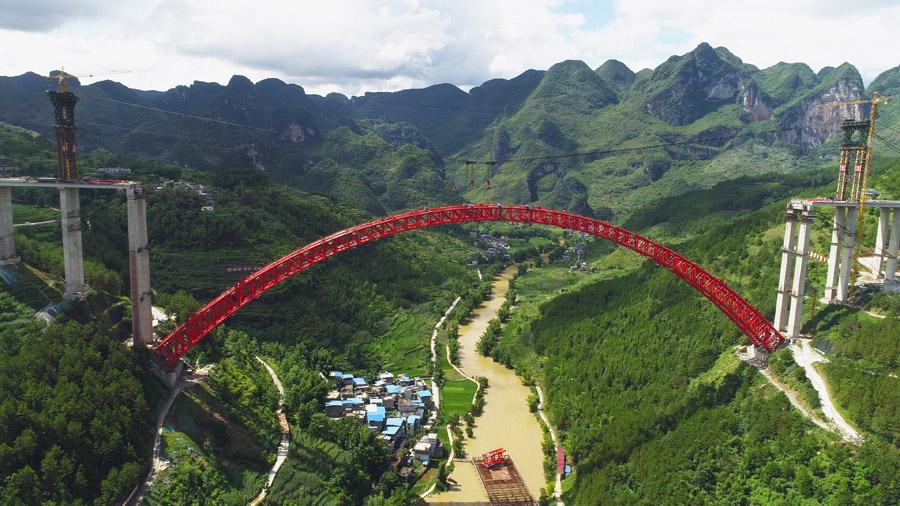 The last section is put into the position to finish the main span of the Daxiaojing Bridge in Guizhou Province, June 30, 2018.  (Photo//chinadaily.com.cn)
