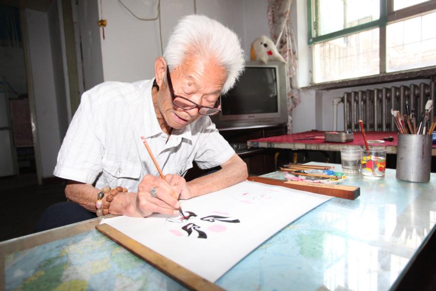 Zhang Fuli, 85, draws a facial mask of Peking Opera at home in Zhangjiakou, North China\'s Hebei Province.(Photo//chinadaily.com.cn)

An 85-year-old man in Zhangjiakou, North China\'s Hebei Province has been painting Peking Opera facial masks for more than 50 years. Zhang Fuli used to be a professional performer of wusheng (a male martial-arts role in Peking Opera) when he was young. Based on his love for operas, Zhang draws facial masks as an amateur and has made more than 700 masks.