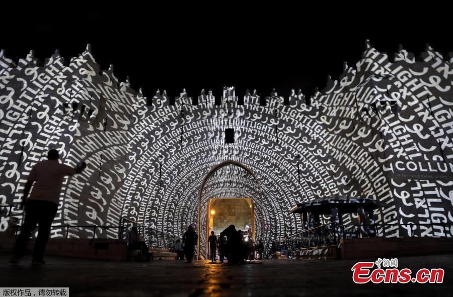 People stand near Damascus Gate outside Jerusalem\'s Old City as it is projected with images during the annual Light Festival, June 28, 2018. (Photo/Agencies)
