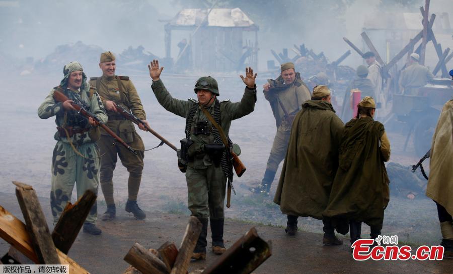 Military enthusiasts take part in a re-enactment of a World War II battle on the eve of Independence Day at the \