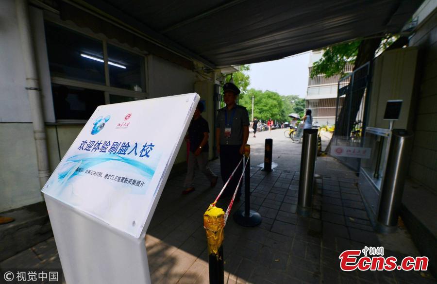 A student undergoes a facial recognition test before entering a school gate at Peking University in Beijing, July 3, 2018. Peking University is the first in China to adopt such a more powerful facial recognition system, capable of accurately and efficiently comparing one person’s facial data with the information of many others. (Photo/VCG)