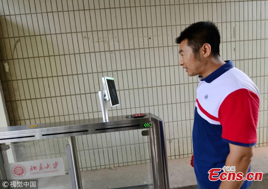A student undergoes a facial recognition test before entering a school gate at Peking University in Beijing, July 3, 2018. Peking University is the first in China to adopt such a more powerful facial recognition system, capable of accurately and efficiently comparing one person’s facial data with the information of many others. (Photo/VCG)