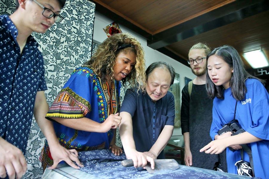 Chinese and British students from the China Academy of Art\'s creative fashion design camp observe traditional printing and dyeing of Chinese blue calico in Nantong, East China\'s Jiangsu Province, on July 3, 2018.  (Photo/Asianewsphoto)