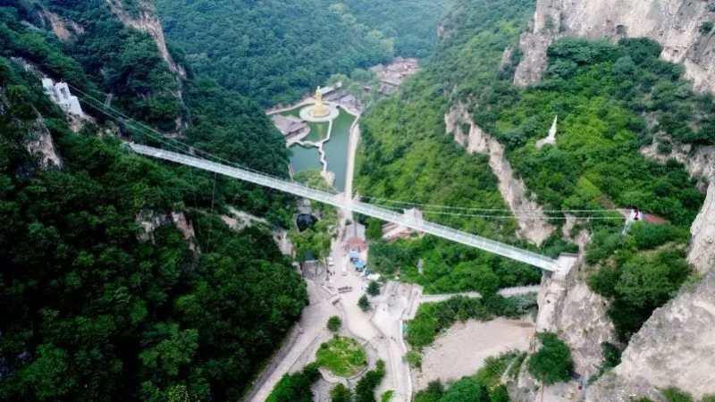 A 168-meter-long 5D glass suspension bridge opened to the public in Cangshan mountain scenic spot in Yuxian county in Shanxi on June 29, 2018. The bridge is 108 meters above the valley bottom. The glass, which is one meter thick, can bear a load of up to 6 tons. (Photo provided to chinadaily.com.cn)