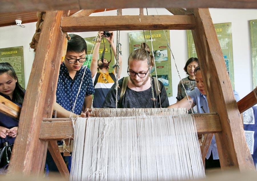 Chinese and British students from the China Academy of Art\'s creative fashion design camp experience traditional Chinese textile craft at the Blue Calico Museum in Nantong, East China\'s Jiangsu Province, on July 3, 2018. The process of making blue calico has been listed as a state-level intangible cultural heritage in China.  (Photo/Asianewsphoto)