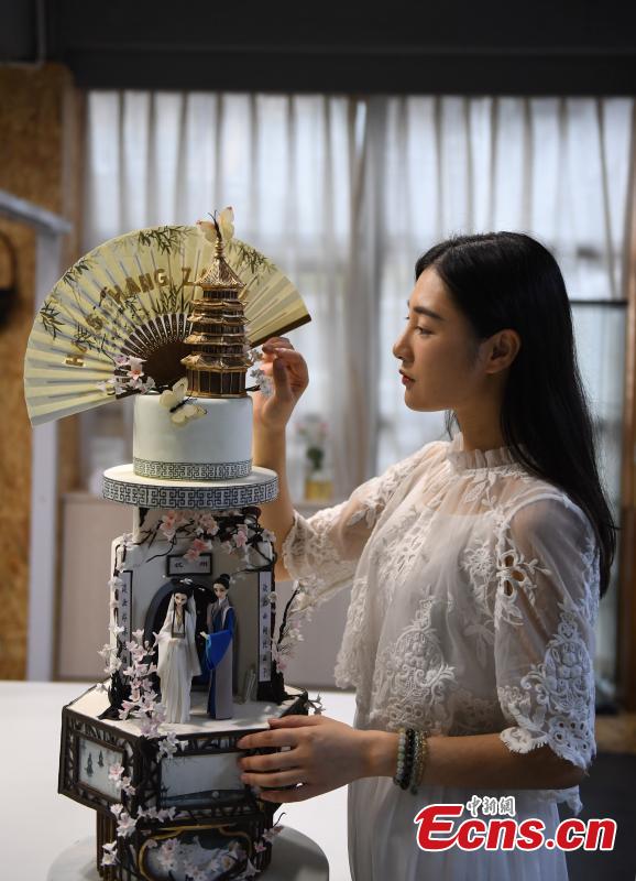 Baker Chen Yao shows her fondant cakes in Hangzhou City, the capital of east China\'s Zhejiang Province on July 5, 2018. Chen is now well-known for combining icons of local Chinese culture with traditional fondant cake recipe. (Photo: China News Service/ Wang Gang)