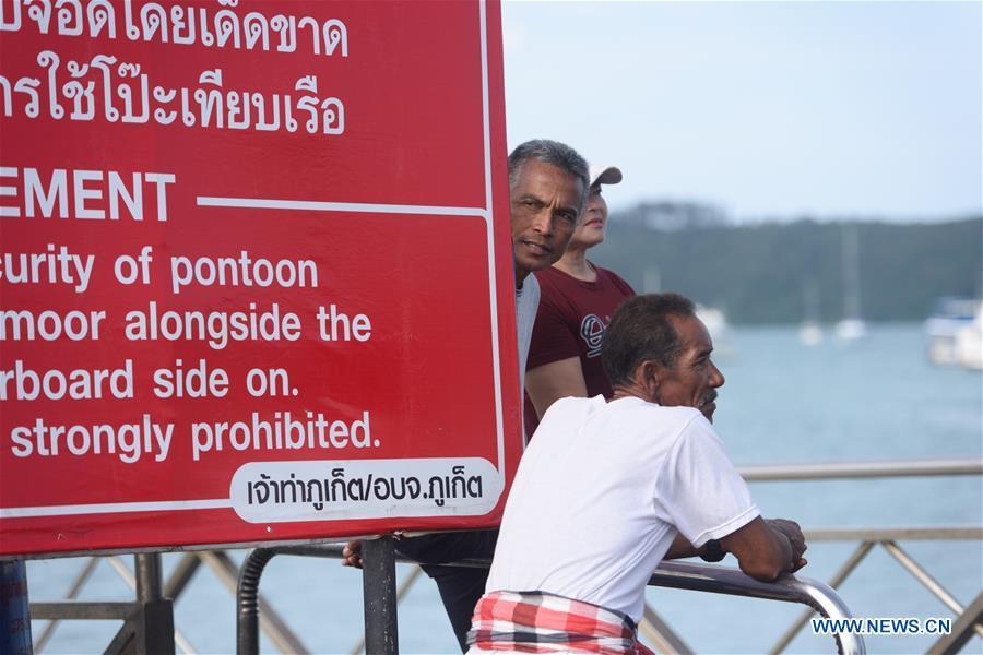 People wait for information about the rescue at a dock in Phuket, Thailand, July 6, 2018. At least 33 passengers were killed and 23 others still missing after two boats carrying some 133 tourists capsized in rough sea waters in southern Thailand, Governor of Thailand\'s Phuket Province Norraphat Plodthong said on Friday. (Xinhua/Qin Qing)