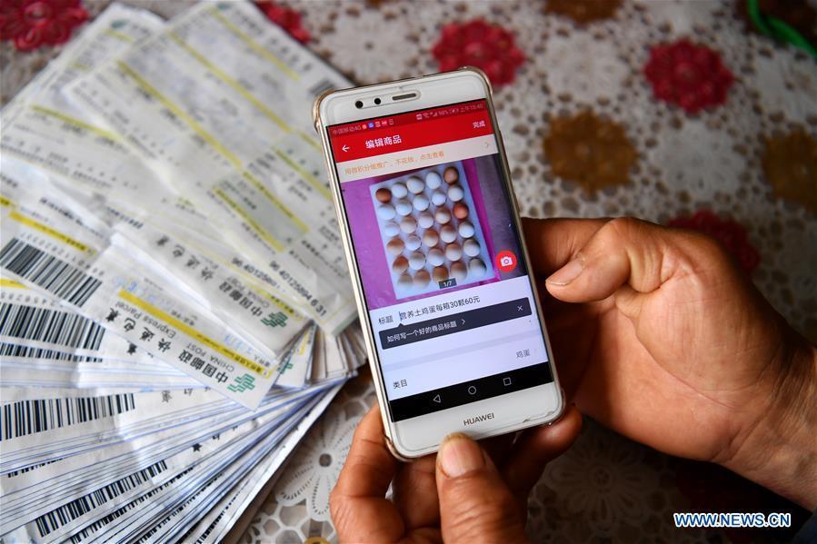 Wang Chengsheng presents the webpage of his online business in Lingtou Village of Wuxiang County, north China\'s Shanxi Province, July 4, 2018. Online business helped villagers sell their farm products, significantly increasing the average incomes of local residents in Lingtou Village. (Xinhua/Zhan Yan)