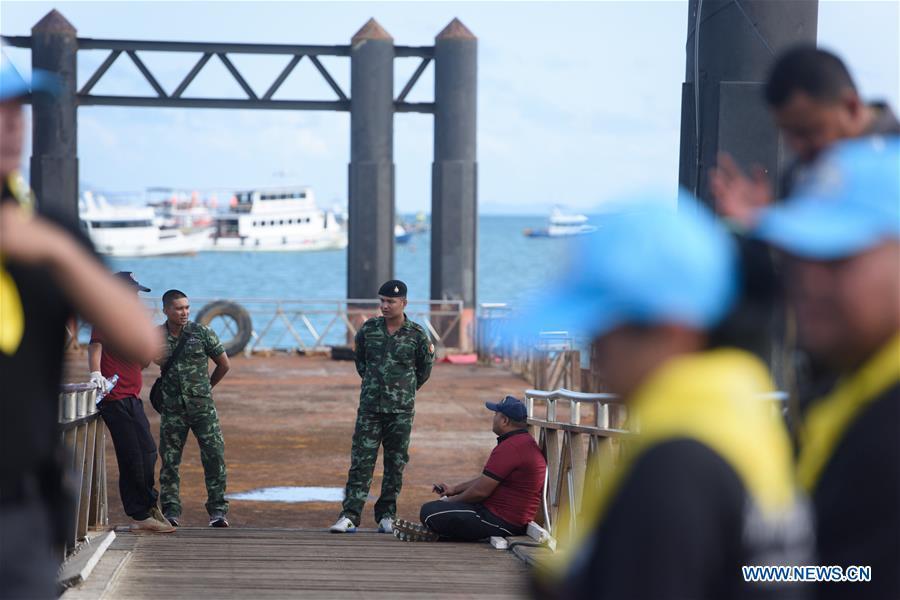 Thai soldiers and policemen are seen at a dock in Phuket, Thailand, July 6, 2018. At least 33 passengers were killed and 23 others still missing after two boats carrying some 133 tourists capsized in rough sea waters in southern Thailand, Governor of Thailand\'s Phuket Province Norraphat Plodthong said on Friday. (Xinhua/Qin Qing)