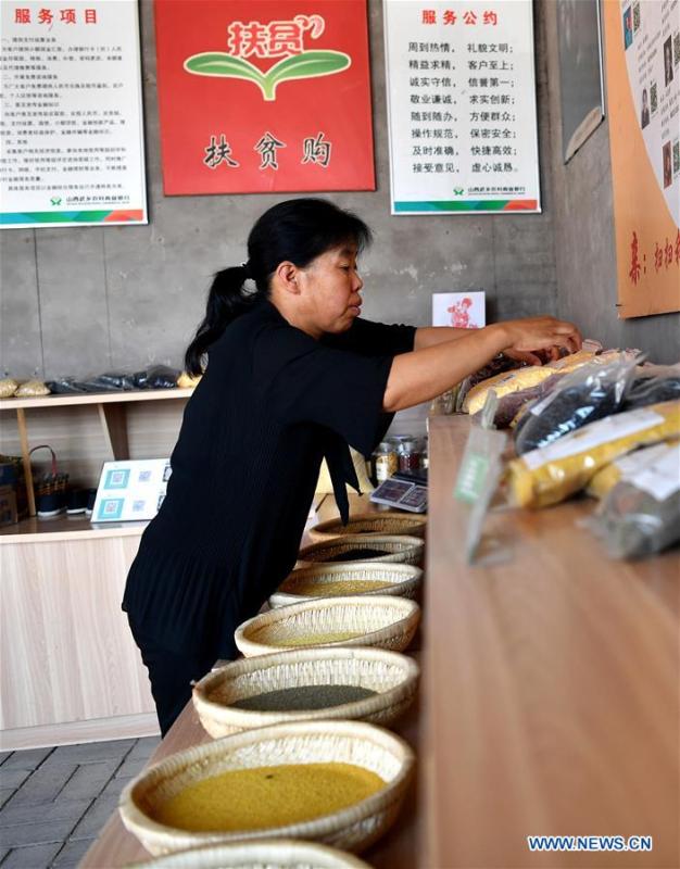 Zhang Xiaoying sorts out goods in Lingtou Village of Wuxiang County, north China\'s Shanxi Province, July 5, 2018. Online business helped villagers sell their farm products, significantly increasing the average incomes of local residents in Lingtou Village. (Xinhua/Zhan Yan)