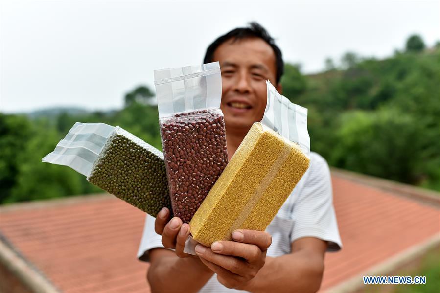 Wei Baoyu presents his products in Lingtou Village of Wuxiang County, north China\'s Shanxi Province, July 3, 2018. Online business helped villagers sell their farm products, significantly increasing the average incomes of local residents in Lingtou Village. (Xinhua/Zhan Yan)