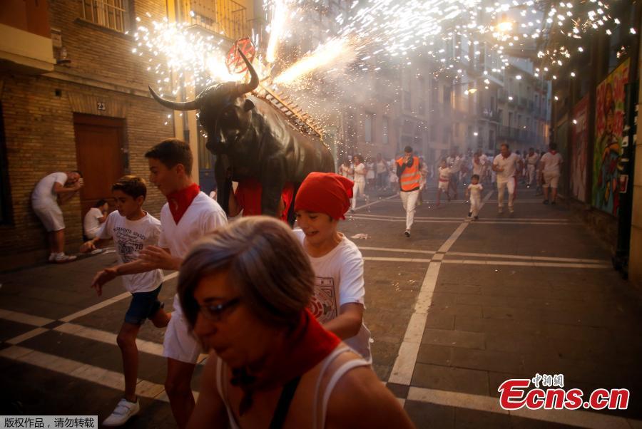Revelers run from the Fire Bull, a man carrying a bull figure packed with fireworks, at the San Fermin festival in Pamplona, Spain July 8, 2018. (Photo/Agencies)