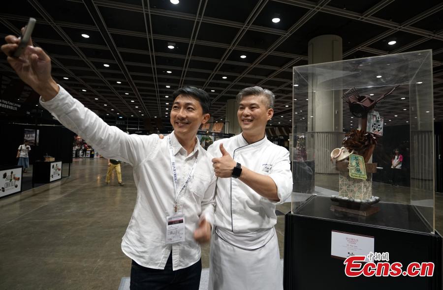 Chef Li Shaohui (R) poses with his chocolate creation at the first Salon du Chocolat at the Hong Kong Convention and Exhibition Center, July 6, 2018. Salon du Chocolat, one of the world’s biggest chocolate events, showcases chocolate sculptures inspired by Hong Kong culture and the Year of the Dog. Meanwhile, guests were also able to sample award-winning creations during a live pastry show. (Photo: China News Service/Zhang Wei)
