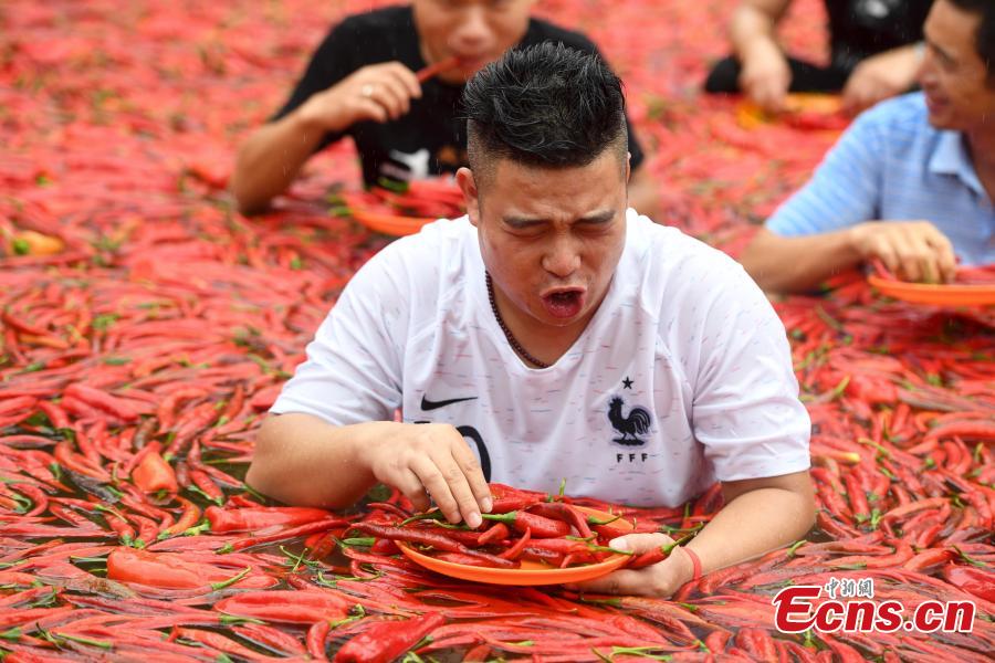 A participant chews chili peppers in a contest in Ningxiang City, Central China’s Hunan Province, July 8, 2018. Tang Shuaihui, a local resident, swallowed 50 chili peppers in one minute to win first prize. (Photo: China News Service/Yang Huafeng)