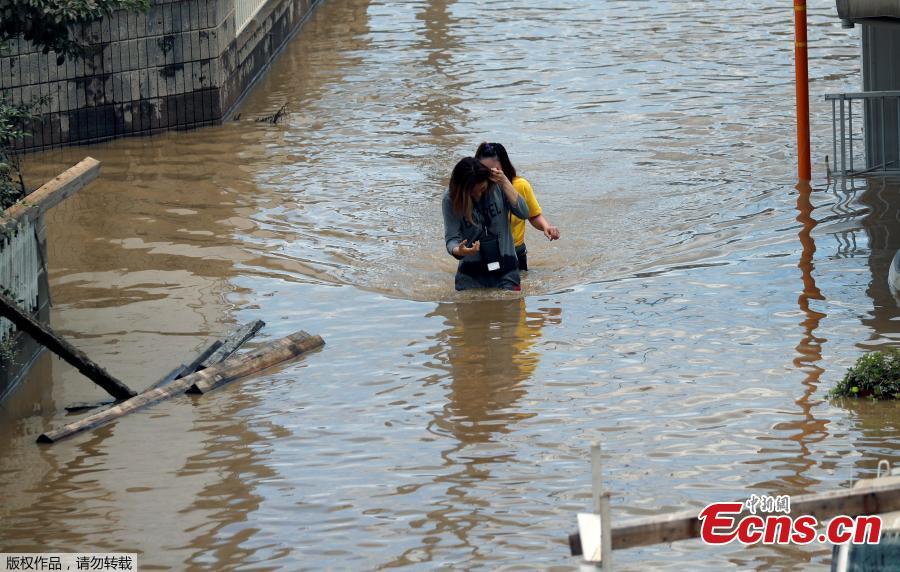 Women make their way through a flooded area in Mabi town in Kurashiki, Okayama Prefecture, Japan, July 8, 2018. The death toll from torrential rain and landslides in western Japan rose to 88 people early on Monday, with dozens still missing after the rescue of more than 2,000 stranded in the city of Kurashiki.(Photo/Agencies)