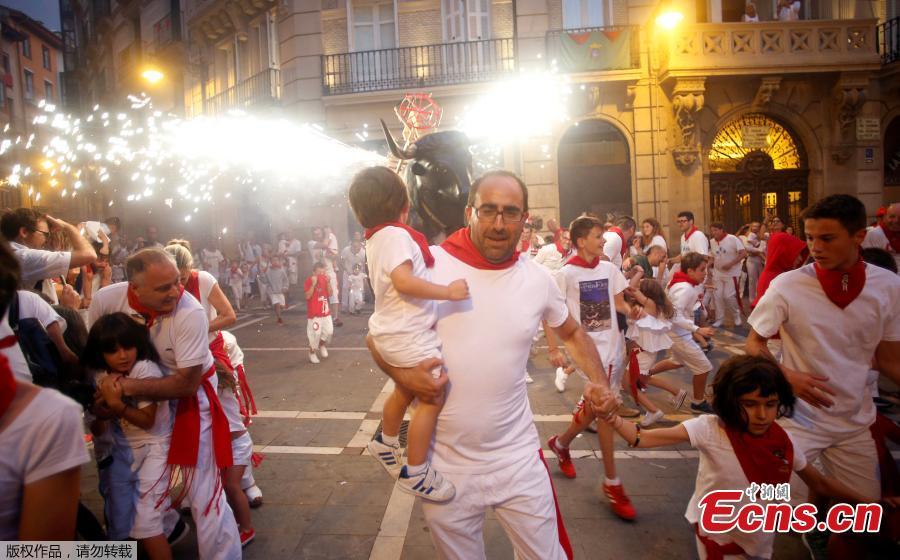 Revelers run from the Fire Bull, a man carrying a bull figure packed with fireworks, at the San Fermin festival in Pamplona, Spain July 8, 2018. (Photo/Agencies)