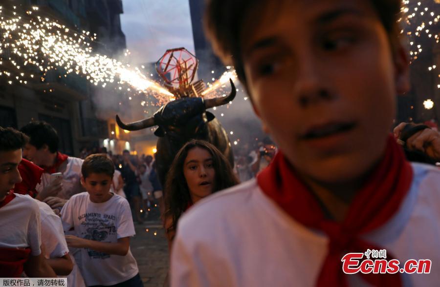 Revelers run from the Fire Bull, a man carrying a bull figure packed with fireworks, at the San Fermin festival in Pamplona, Spain July 8, 2018. (Photo/Agencies)