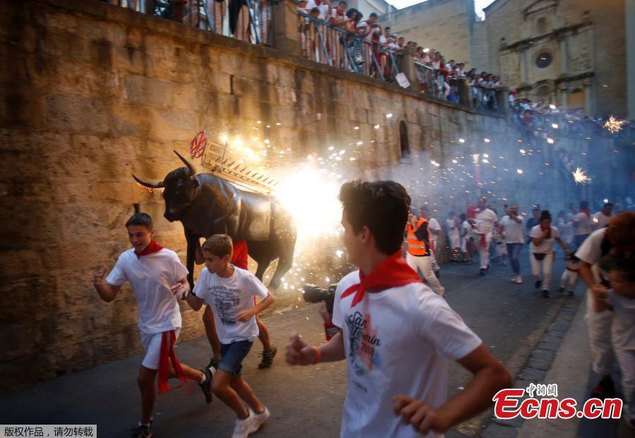 Revelers run from the Fire Bull, a man carrying a bull figure packed with fireworks, at the San Fermin festival in Pamplona, Spain July 8, 2018. (Photo/Agencies)