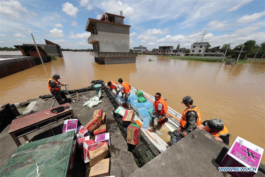 Rescue workers transport relief supplies in Dongxiang Disctrict of Fuzhou City, east China\'s Jiangxi Province, July 8, 2018. Flood caused by heavy rain damaged crops and housings in Maxu Township of Dongxiang and rescue groups were set up to help the affected people. (Xinhua/He Jianghua)