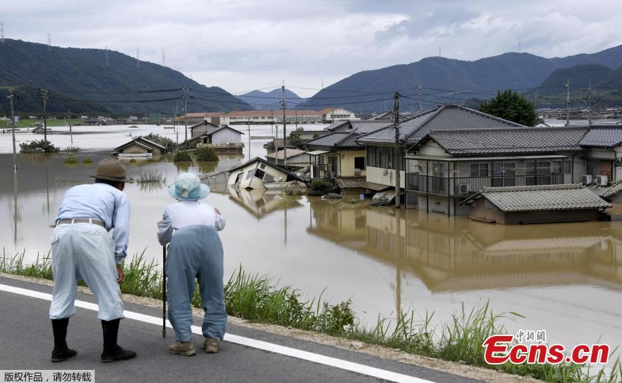 An elderly couple looks at a flooded area after heavy rain in Kurashiki, Okayama Prefecture, Japan, in this photo taken by Kyodo July 8, 2018. The death toll from widespread flooding and landslides rose to 126, according to Japanese authorities.  (Photo/Agencies)