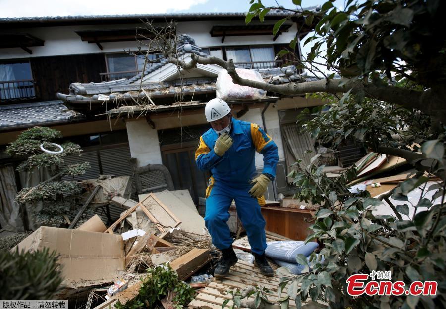 A police officer checks a submerged and destroyed house in a flood affected area in Mabi town in Kurashiki, Okayama Prefecture, Japan, July 10, 2018.The death toll from widespread flooding and landslides rose to 126, according to Japanese authorities.  (Photo/Agencies)