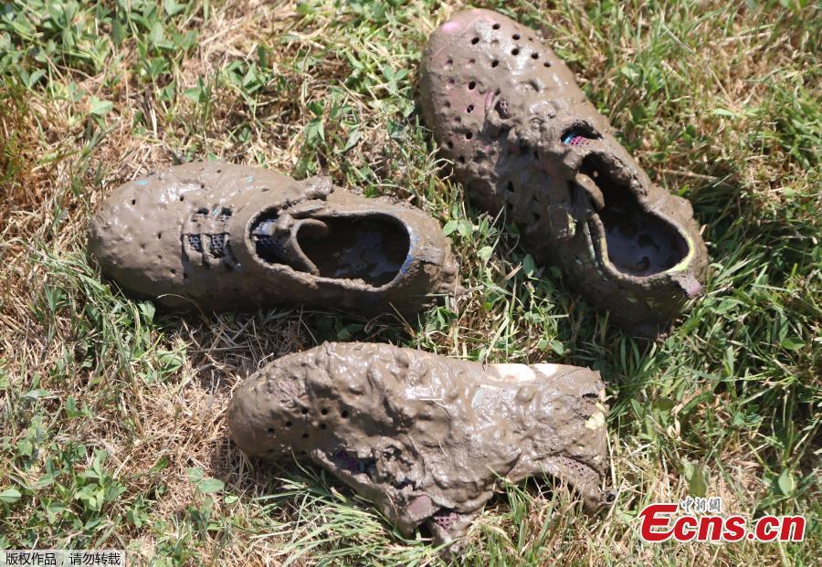 Mud caked shoes are seen next to the giant 75\' x 150\' mud pit at the Nankin Mills Park, July 10, 2018, in Westland, Mich. The event marked the 31st year Wayne County Parks has hosted Mud Day. While much of the event was children and parents playing in the mud, park officials organized various races and a limbo line. (Photo/Agencies)