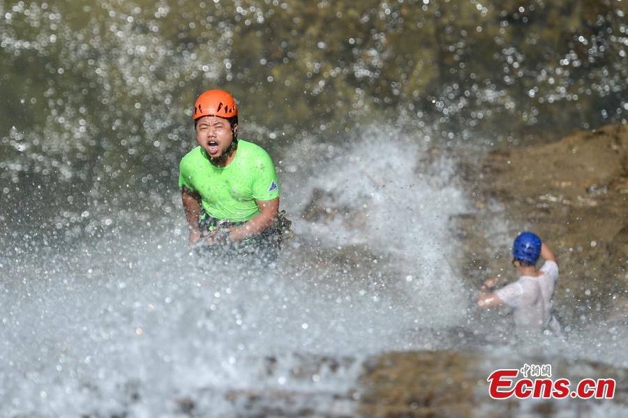 Ma Ming abseils down a 106-meter-high waterfall in Rucheng County, Central China’s Hunan Province, July 10, 2018. Two participants took five minutes to descend a rope from a glass walkway at the top of a cliff to the ground below. (Photo: China News Service/Yang Huafeng)