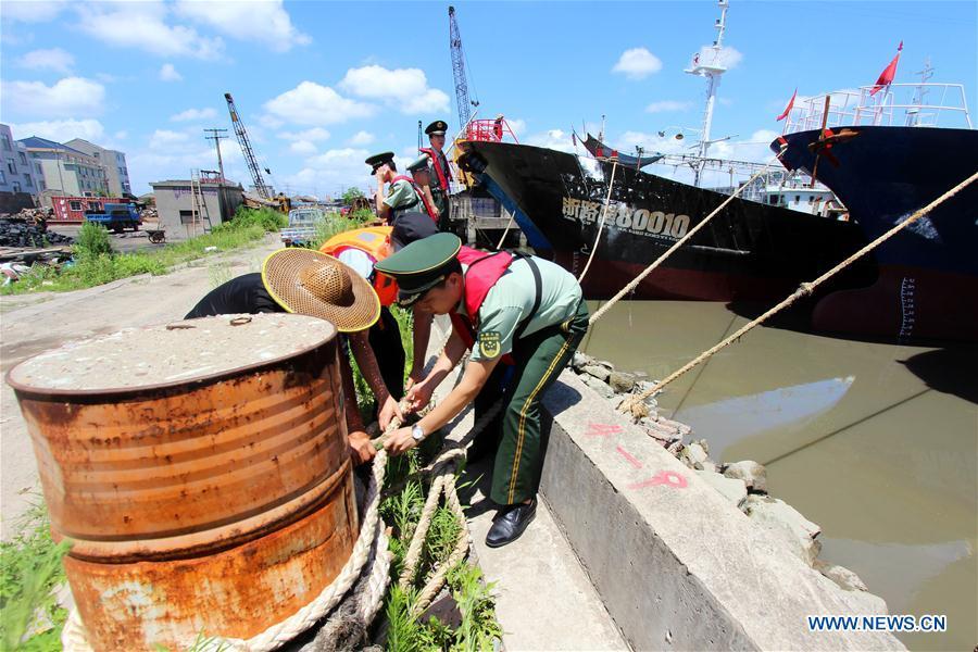 Police officers and soldiers help a fisherman moor fishing boats in Taizhou, east China\'s Zhejiang Province, July 10, 2018. China Meteorological Administration on Tuesday issued this year\'s first red alert for typhoon as the Typhoon Maria or the 8th of the year approaches the Chinese coast. Typhoon Maria is likely to sweep Taiwan, Fujian, Jiangxi and part of Zhejiang on Tuesday and Wednesday.(Xinhua/Jiang Youqin)