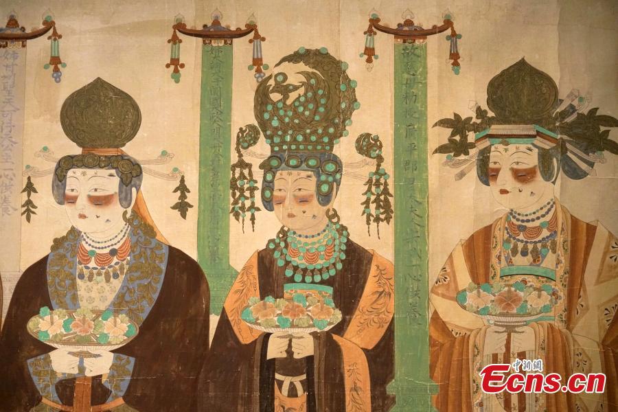 Visitors look at the Digital Dunhuang - Tales of Heaven and Earth exhibition at the Hong Kong Heritage Museum, July 10, 2018. Jointly presented by the Hong Kong Leisure and Cultural Services Department and the Dunhuang Academy, the exhibition highlights the achievements of digitization projects at the Dunhuang Academy, together with a presentation of unearthed artefacts, the grotto art of Dunhuang, and the latest multimedia technology. The Dunhuang Academy has made substantial achievements in digitization, 3D scanning and virtual reality representation of the Dunhuang relics. (Photo: China News Service/Zhang Wei)