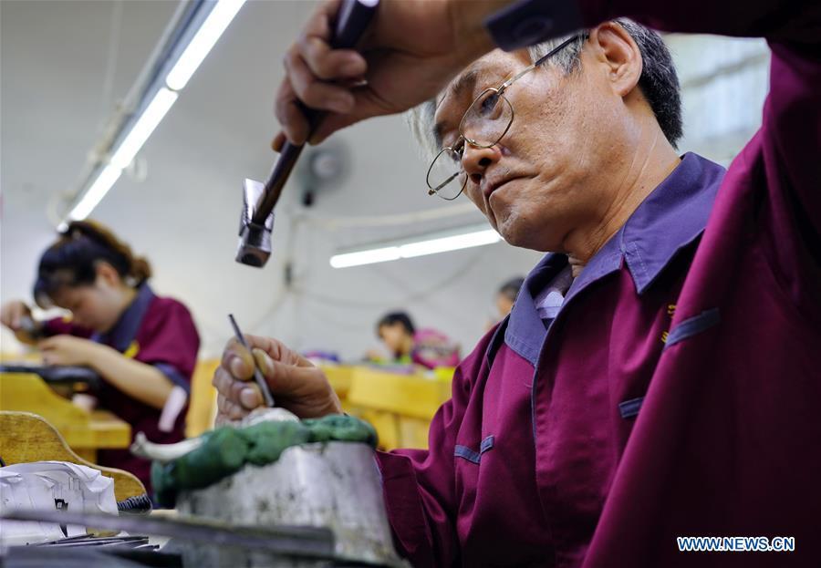 Workers make silverwares at a workshop in Malanyu Township in Zunhua City, north China\'s Hebei Province, July 11, 2018. Gold and silver processing in Malanyu Township has a long history and the industry is expanding as craftsmen blend modern elements with traditional techniques in recent years. To date, there are more than 80 enterprises that provide over 2,000 jobs for local residents. (Xinhua/Mu Yu)