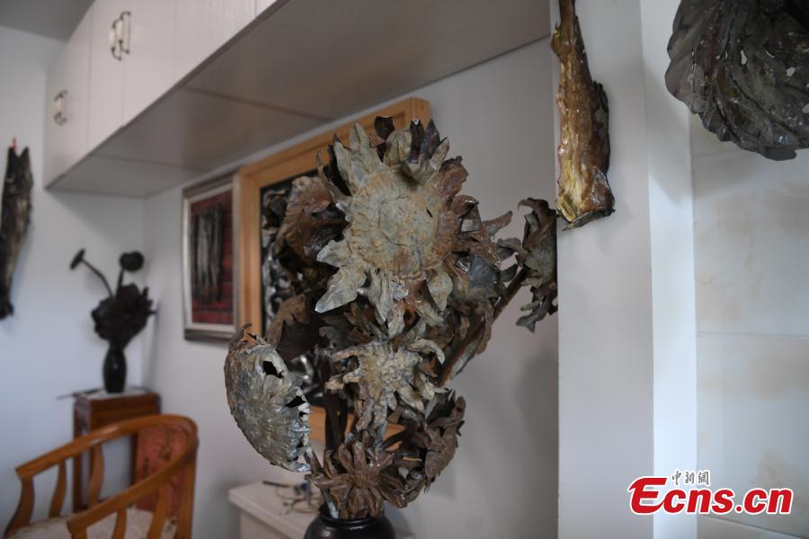 Sui Jincai, an art teacher, shows iron artworks in Changchun City, Jilin Province, July 11, 2018. Sui uses acrylic paints and iron materials to create vivid 3D creations. (Photo: China News Service/Zhang Yao)